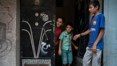 8-year-old Mohamed al-Dalo, center, who was shot in the leg during a demonstration, stands at the entrance of his house in Gaza City. Ever since Hamas launched demonstrations in March against Israel's blockade of Gaza, children have been a constant presence in the crowds. Since then, U.N. figures show that 948 children under 18 have been shot by Israeli forces and 2,295 have been hospitalized, including 17 who have had a limb amputated. AP