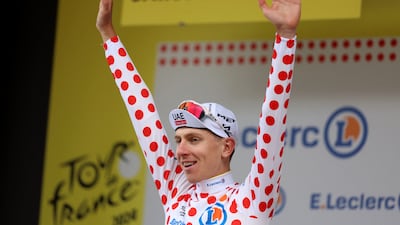 UAE Team Emirates' Tadej Pogacar celebrates on the podium wearing the polka-dot jersey after winning Stage 14. Reuters