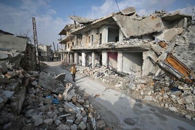 A Syrian man walks past damaged buildings in the town of Ihsim in the southern countryside of Idlib. AFP