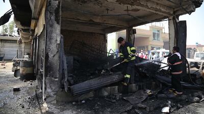 Firefighters inspect the scene of the suicide bomb attack. EPA