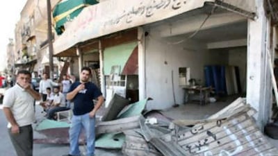 Syrians react as they inspect the damage following a bomb blast in Damascus in September.