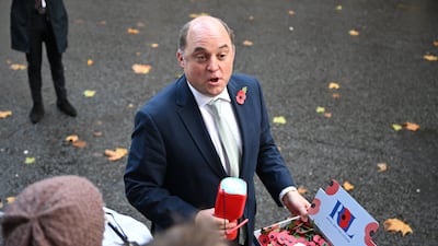 Mr Wallace sells poppies to members of the media as he leaves a Cabinet meeting in Downing Street in November. Getty Images