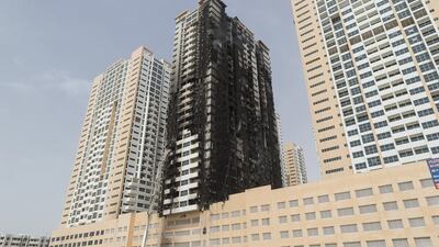The badly damaged outside of Tower Eight at the Ajman One development where the fire started before spreading to other buildings nearby. Antonie Robertson / The National
