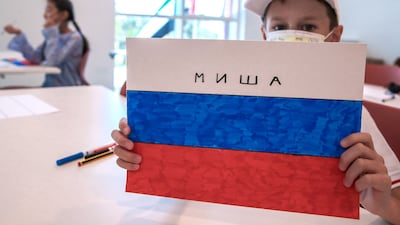 A pupils draws the Russian national flag in art class.