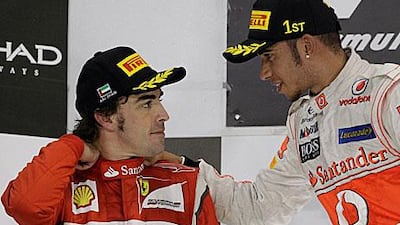 Fernando Alonso, left, chats to Abu Dhabi Grand Prix winner Lewis Hamilton on the podium.