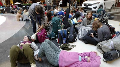 Abby Nass (left) and Cara Martin (right) wait as part of the mission group Adventures In Missions, to find out if their flight to Guatemala on Delta is on time or cancelled at Hartsfield Jackson Atlanta International Airport in Atlanta. Tami Chappell / Reuters