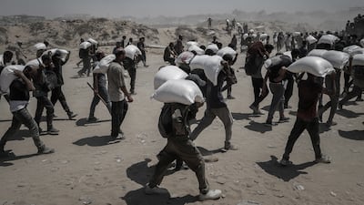 Palestinians carry aid supplies which entered Gaza through Israel on Sunday. Bloomberg