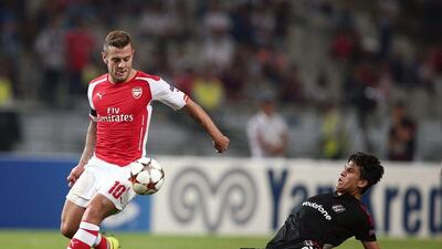 Besiktas's Necip Uysal, left, and Jack Wilshere of Arsenal fight for the ball during their Champions League play-off first leg match in Istanbul last Tuesday. AP / August 19, 2014