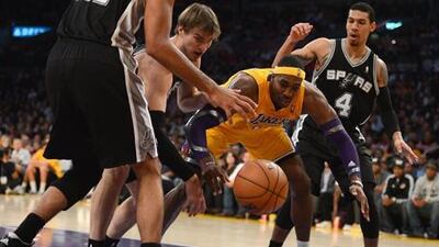 Los Angeles Lakers' Dwight Howard reaches for a rebound against San Antonio's Tiago Splitter and Danny Green