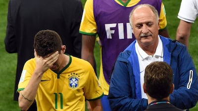 Brazil’s head coach Luiz Felipe Scolari leads player Oscar off the pitch after the World Cup 2014 semi-final match between Brazil and Germany at the Estadio Mineirao in Belo Horizonte, Brazil. EPA/Andreas Geber