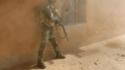 An Iraqi soldier searches a house during clashes with ISIL fighters.