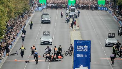 Police remove activists from the track before the start of the Berlin Marathon in Berlin, Germany. AP
