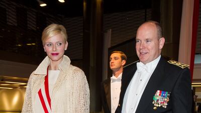 Princess Charlene, in a cream dress and cardigan, and Prince Albert II of Monaco attend the Monaco National Day Gala Concert on November 19, 2012. Getty Images