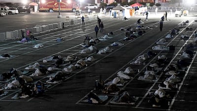 People are shown in social-distancing boxes at a temporary homeless shelter set up in a parking lot at Cashman Center in Las Vegas, Nevada. AFP