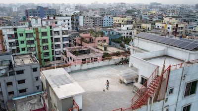 This picture taken on March 23, 2020 shows Samin Sharar, 9, playing on the rooftop of his building in Dhaka, as he avoids going out due to fears over the COVID-19 novel coronavirus. / AFP / Munir UZ ZAMAN