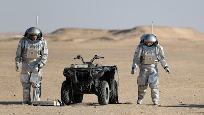 Members of the AMADEE-18 Mars simulation mission wear spacesuits while conducting scientific experiments next to an all-terrain vehicle in Oman's Dhofar desert. Karim Sahib / AFP Photo
