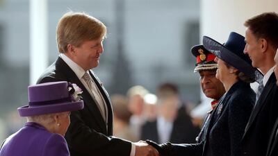 British Prime Minister Theresa May greets Dutch King Willem-Alexander of the Netherlands as Queen Elizabeth II looks on during a Ceremonial Welcome on Horse Guards Parade. The last State Visit from the Netherlands was by Queen Beatrix and Prince Claus in 1982. Matt Dunham / AFP