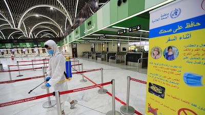 A worker wearing a protective suit sprays interiors departure hall of Baghdad International Airport. REUTERS