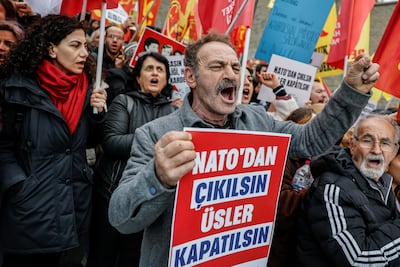 A demonstrator holds a placard that reads 'Leave Nato, close bases', during an anti-war rally outside the US consulate in Istanbul. Reuters