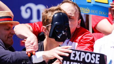 Mr Chestnut is still holding a fistful of hot dogs as he grapples with the protester. Reuters