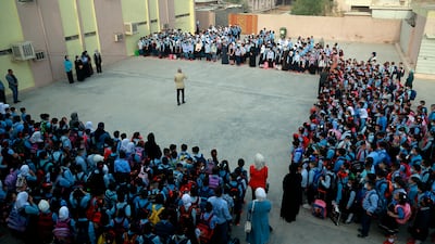 School pupils in masks gather in the playground at the beginning of the school year in Baghdad, Iraq. Children returned to classrooms on Monday for the first time in 18 months – a stoppage caused by the coronavirus pandemic. AP