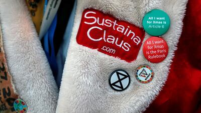 Badges are seen on the jacket of a climate change activist of Extinction Rebellion dressed as Santa Claus. Reuters
