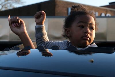 A child holds up her fist during a vigil in Columbus, Ohio on April 21, 2021 to remember Ma’Khia Bryant, 16, who was shot and killed by a Columbus Police Department officer. Police in the US state of Ohio fatally shot a Black teenager who appeared to be lunging at another person with a knife, less than an hour before former officer Derek Chauvin was convicted of murdering George Floyd. The shooting occurred at a tense time with growing outrage against racial injustice and police brutality in the United States, and set off protests in the city of Columbus. / AFP / Jeff Dean