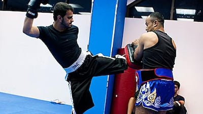 Ahmed Abdul Raheem Ahmed Al Hosani, left, trains with his coach Juma Ben Jama at World Gym in Abu Dhabi. The Emirati, who is deaf and cannot speak, aims to represent the UAE at the Olympics.