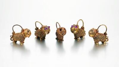 A set of five lion-form gold earrings, Persia, 12th centuryEstimate: £6,000- 8,000each composed of gold, designed as stylised lions decorated with twisted wire, hinged hook for hanging, two with later-inset pink stones to eyes Quantity: 5each: 1.9cm. height.