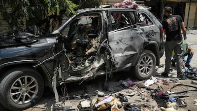 First responders inspect the wreckage of a car reportedly targeted by an Israeli strike in Nabatieh. AFP