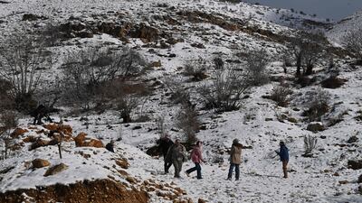 People play in snow in the Syrian town of Bludan, some 50 kilometres northwest of the capital Damascus on January 14, 2026. (Photo by LOUAI BESHARA / AFP)