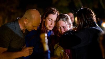 People hug and cry during a vigil to pay tribute to the victims. AFP