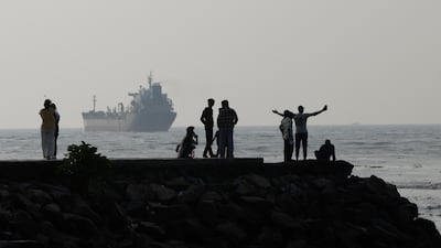 Domestic tourists stand on the seaside promenade at Fort Kochi beach as the oil and chemical products tanker Anantha sails through the Arabian Sea after departing from a port in Kochi, India, on October 12, 2026. Getty Images