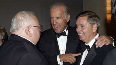 Mr Graham, right, with senator Joseph Biden, who would go on to become US president, and Lee Ewing editor of Aerospace Daily, in 2004. AFP