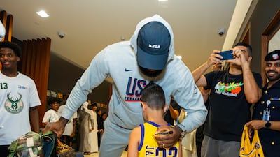Team USA star LeBron James is greeted by a young fan in Abu Dhabi.