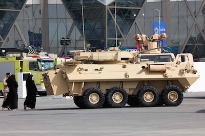 Women walk past an armoured vehicle exhibited at the World Defence Show 2024 held north of the Saudi capital Riyadh. AFP