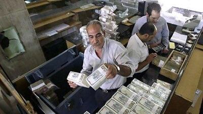 A banker stacks Syrian notess at the Central Bank in Damscus. AFP