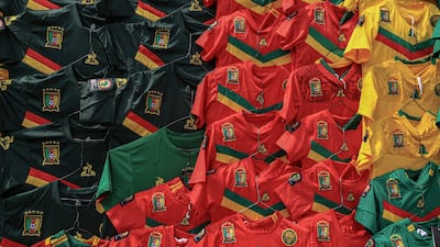 Cameroonian football jerseys hang along a wall at the central market in Yaounde. AFP