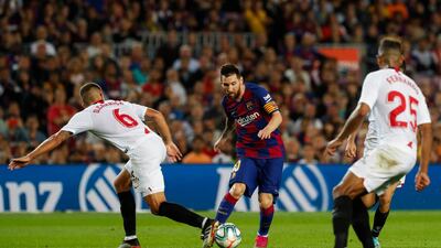 Lionel Messi runs with the ball next to Sevilla defenders on October 6, 2019. AP Photo