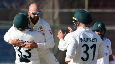 Nathan Lyon celebrates with teammates after dismissing Babar Azam. AFP