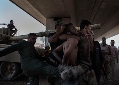 An alleged ISIS fighter is handled by Iraqi armi soldiers right after being captured on the frontline in the old city of Mosul. Photo by Alessio Romenzi