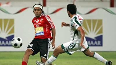 Al Ahli's Hassan Ali, left, plays the ball past an Al Khaleej player during his side's 3-0 victory.