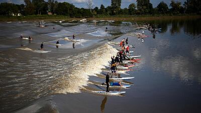 Surfers and paddleboarders ride the Mascaret, or tidal bore, along the Dordogne river in Saint-Pardon, south-western France. AFP