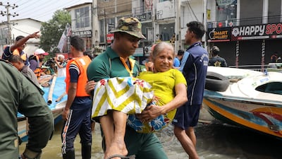 Rescue workers take Colombo residents to boats amid evacuation operations. EPA