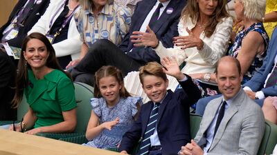 Prince George waves as he watches the tennis with his family. AP