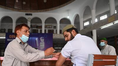 A health worker inoculates a student with CanSino Biologics' Covid-19 vaccine in Lahore, Pakistan. AFP