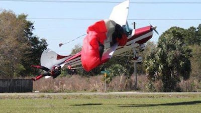 The skydiver’s parachute becomes tangled around the wing of the plane, dragging the skydiver behind it. Tim Telford / AP Photo / March 8, 2014