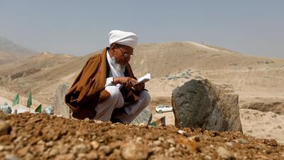 An Afghan cleric prays over the grave of one of the victims of yesterday's suicide attack. Reuters