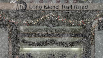 Pedestrians get out of the snow storm by standing at the entrance of the Long Island Railroad. Seth Wenig / AP Photo