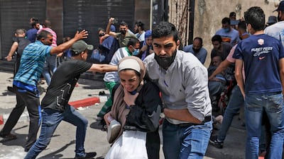 Palestinians flee from a building targeted by an Israeli bombardment in Gaza City. AFP